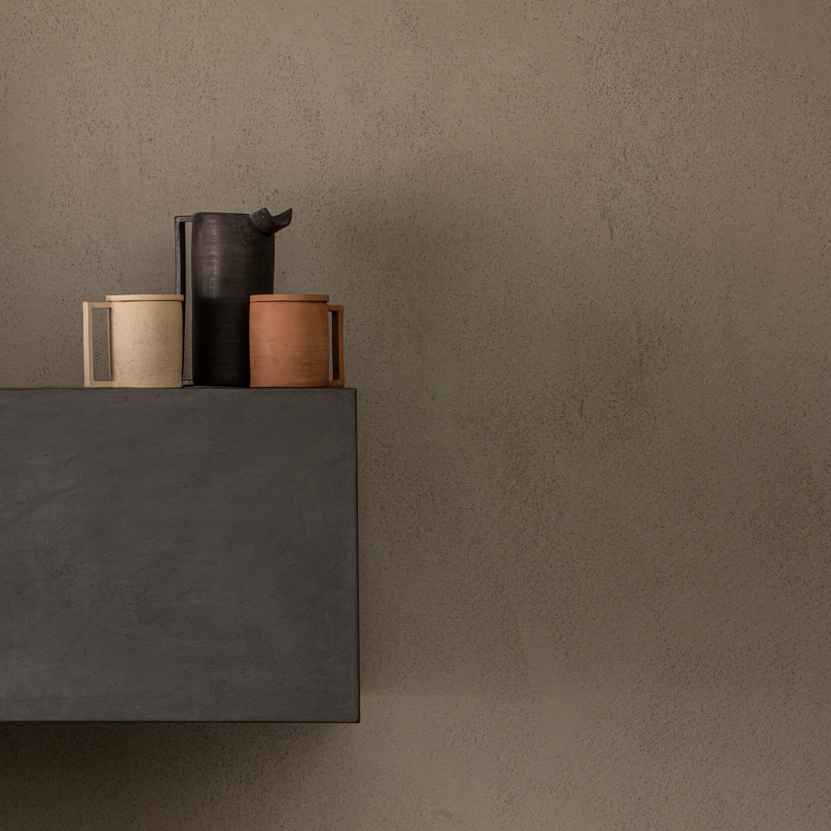 Parete microcemento con vasi in ceramica artigianale